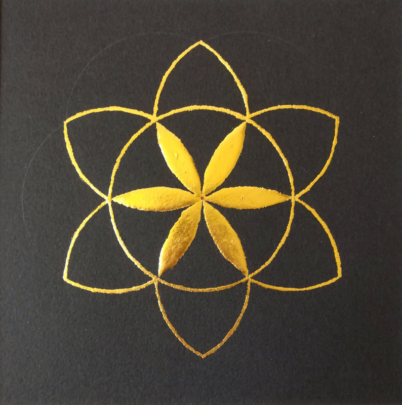 Six fold, circular, geometric design in gold on black paper.